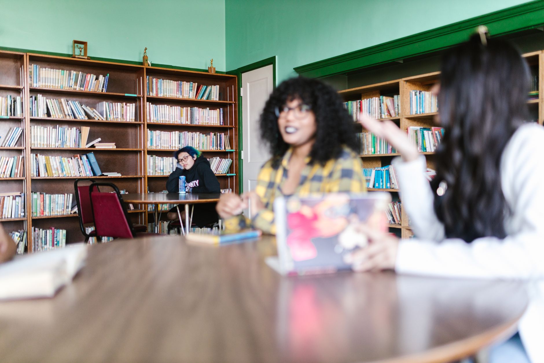 Estudo em grupo numa biblioteca, com livros sobre a mesa