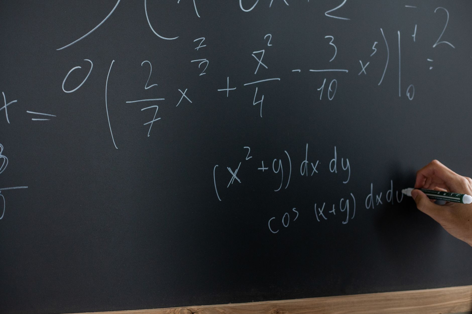Equações de matemática escritas a giz num quadro preto